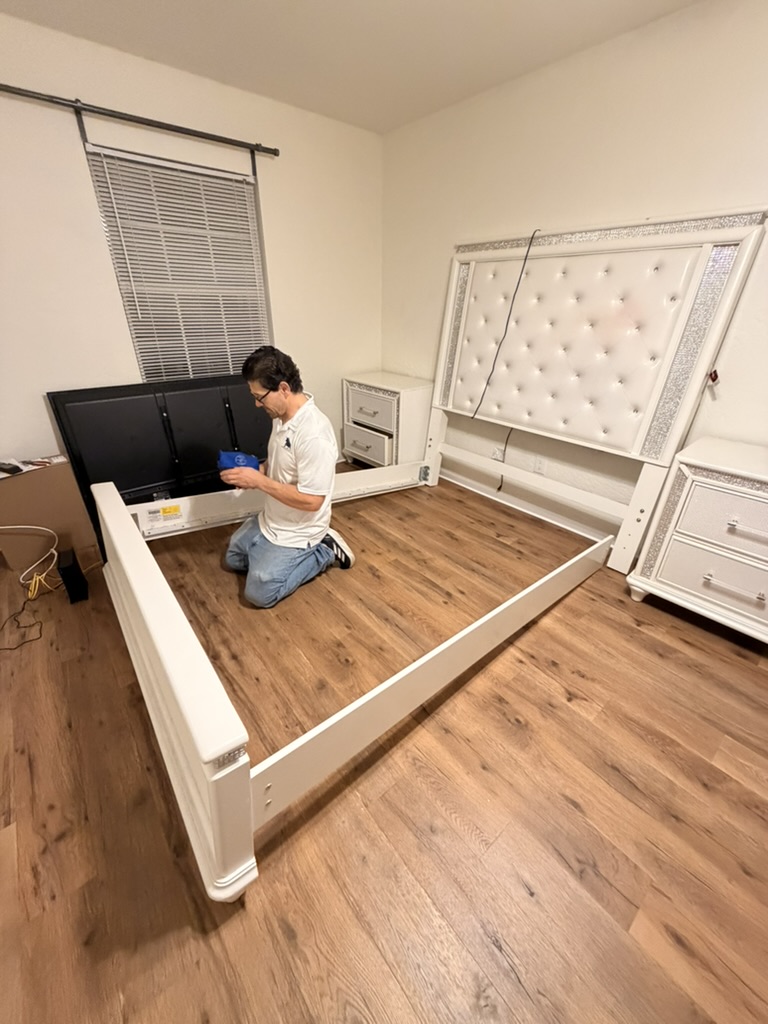 Toro mover assembling a large bedframe in an empty room